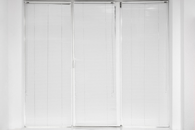 Photo of Window with closed modern horizontal blinds indoors