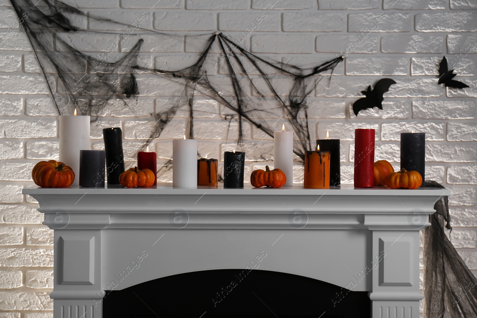 Photo of Fireplace with different Halloween decor indoors. Festive interior