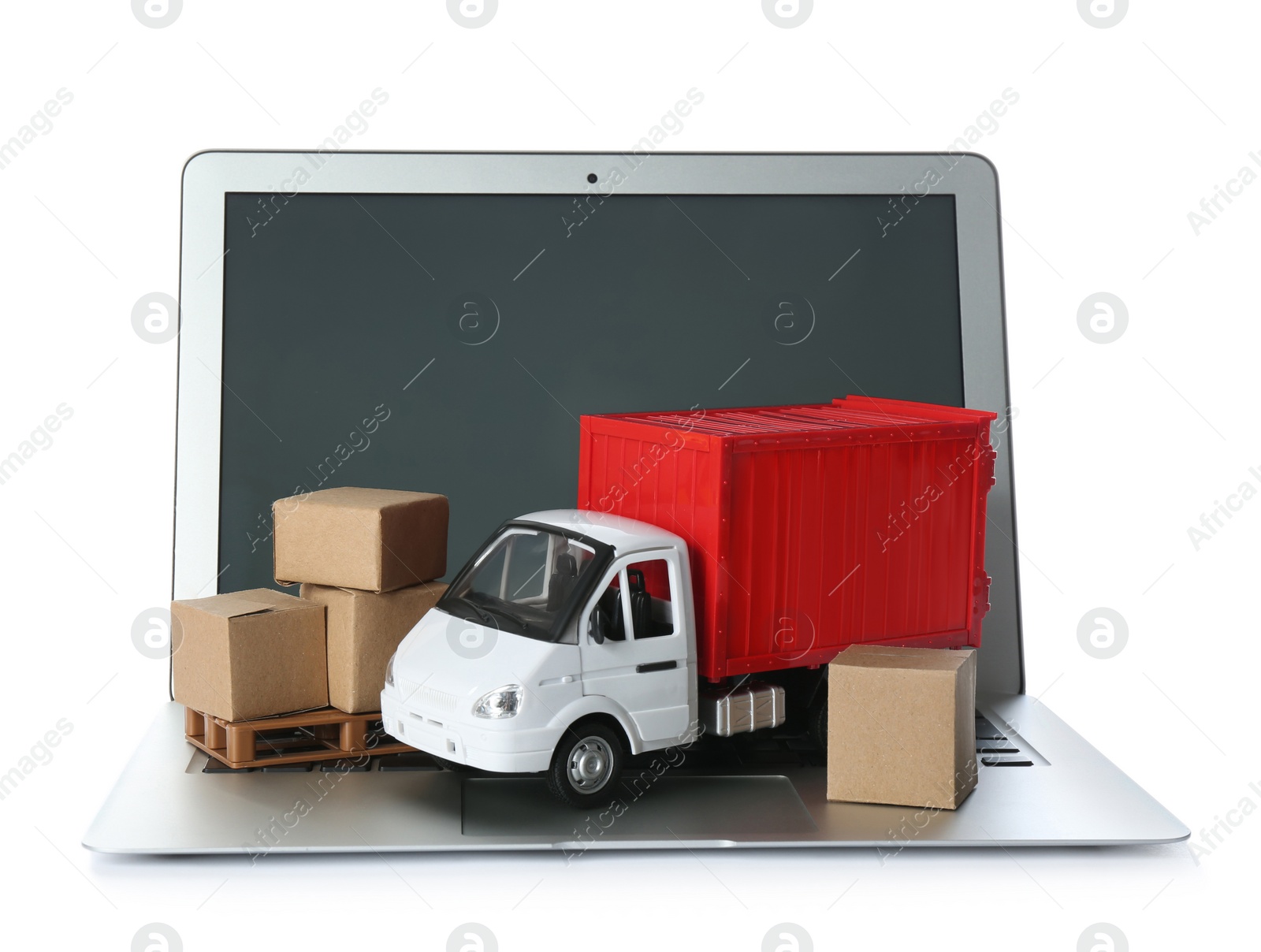 Photo of Laptop, truck model and carton boxes on white background. Courier service