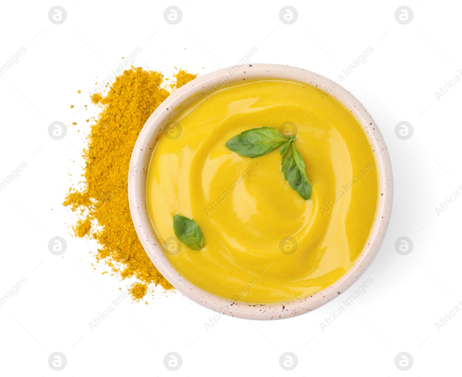 Photo of Bowl with tasty curry sauce, powder and basil leaves isolated on white, top view