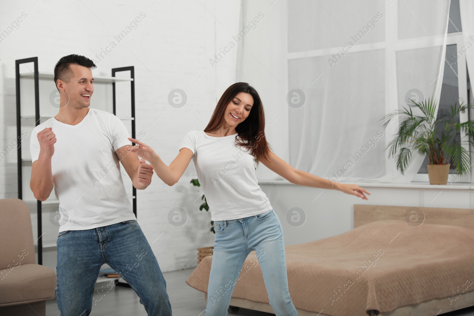 Photo of Happy young couple dancing together at home