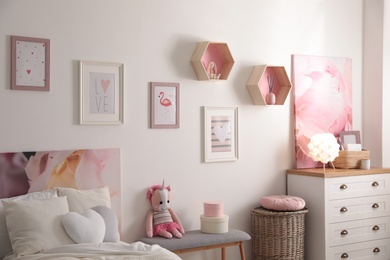 Photo of Stylish child's room interior with beautiful pictures and comfortable bed