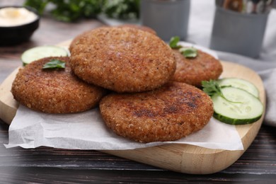 Tasty vegan cutlets served on wooden table, closeup