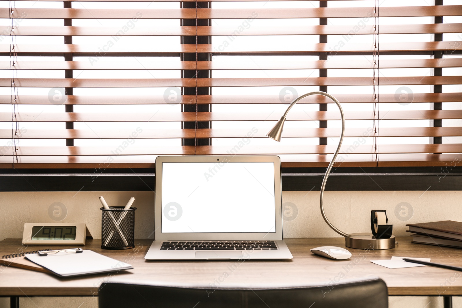 Photo of Modern laptop on table in office. Comfortable workplace