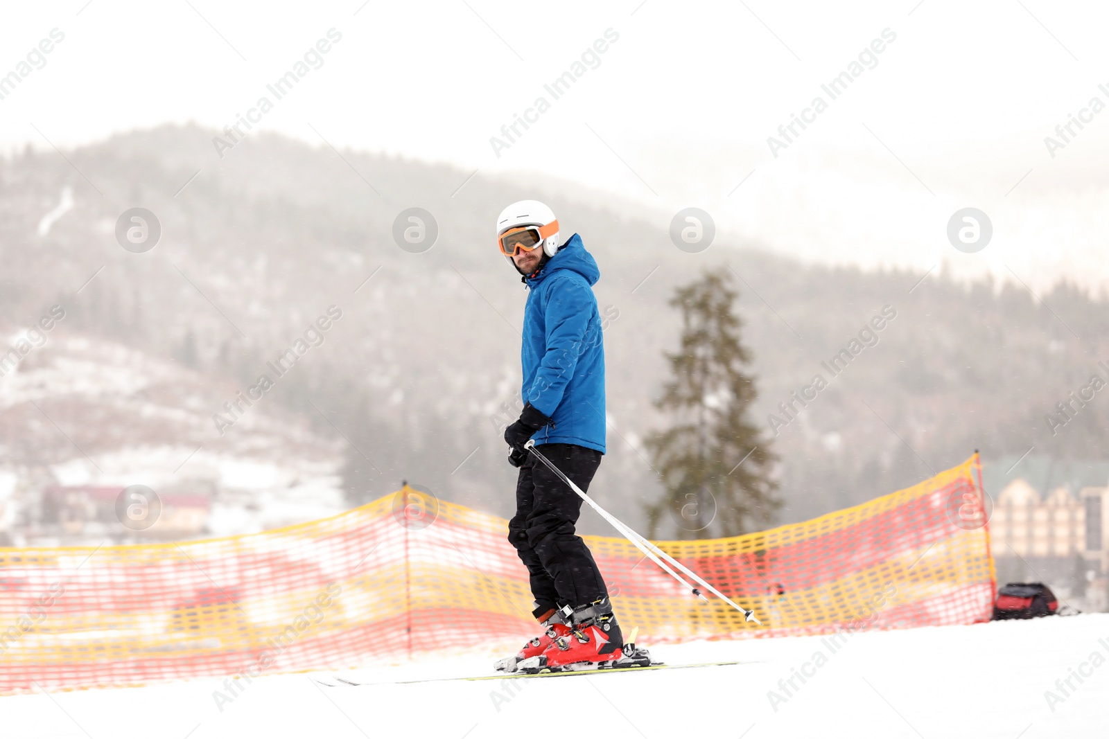 Photo of Skier on slope at resort. Winter vacation