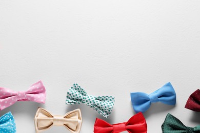Photo of Stylish color bow ties on white background, flat lay. Space for text