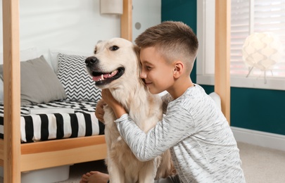 Photo of Little boy with his dog in stylish bedroom interior
