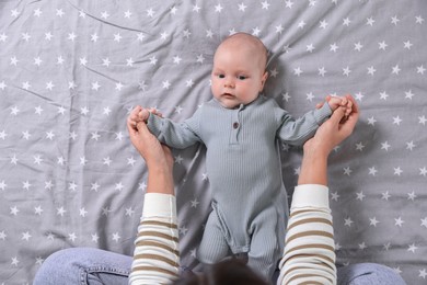 Photo of Mother and her little baby on bed, top view