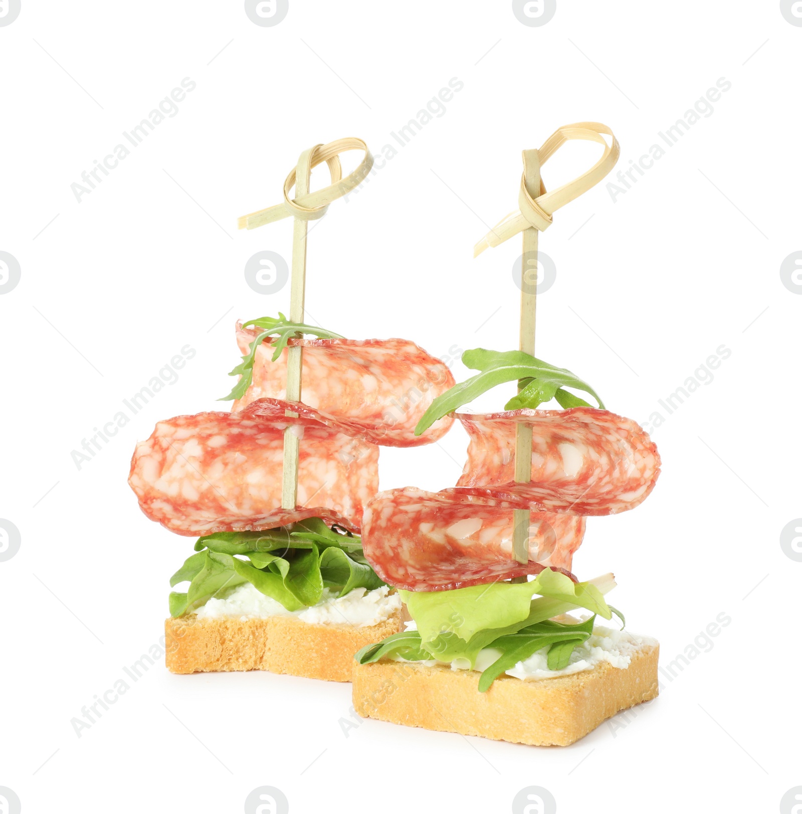 Photo of Tasty canapes with salami, greens and cream cheese isolated on white