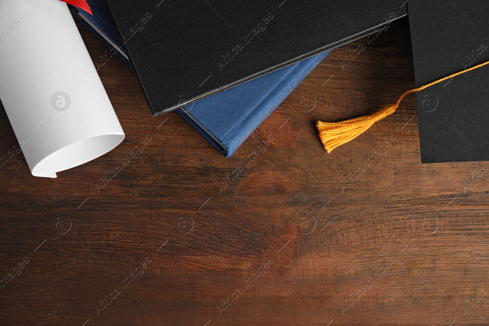 Photo of Flat lay composition with graduation hat and student's diploma on wooden table, space for text