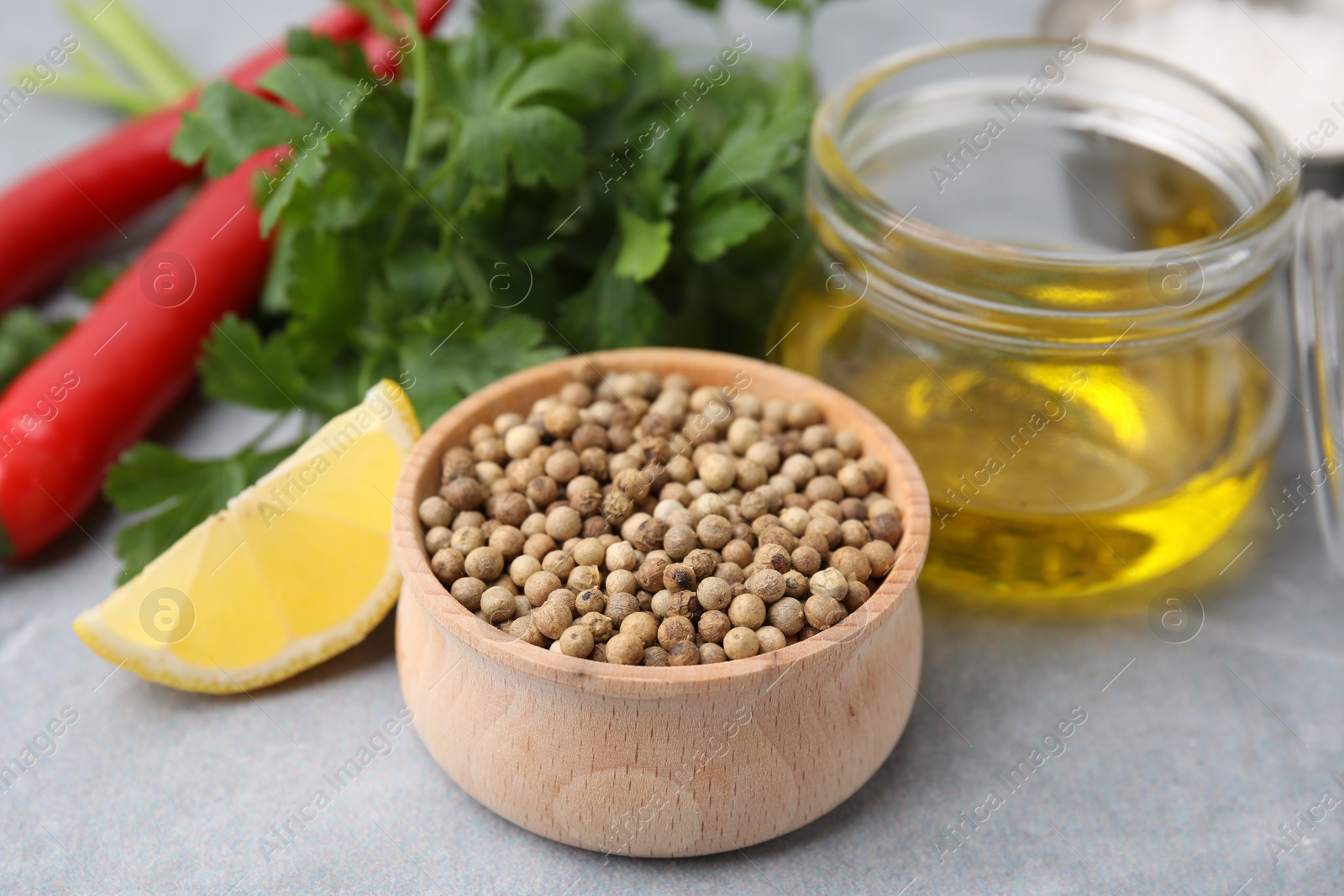 Photo of Aromatic peppercorns and different fresh ingredients for marinade on grey table