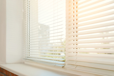 Image of Beautiful view through window with blinds on sunny day, closeup