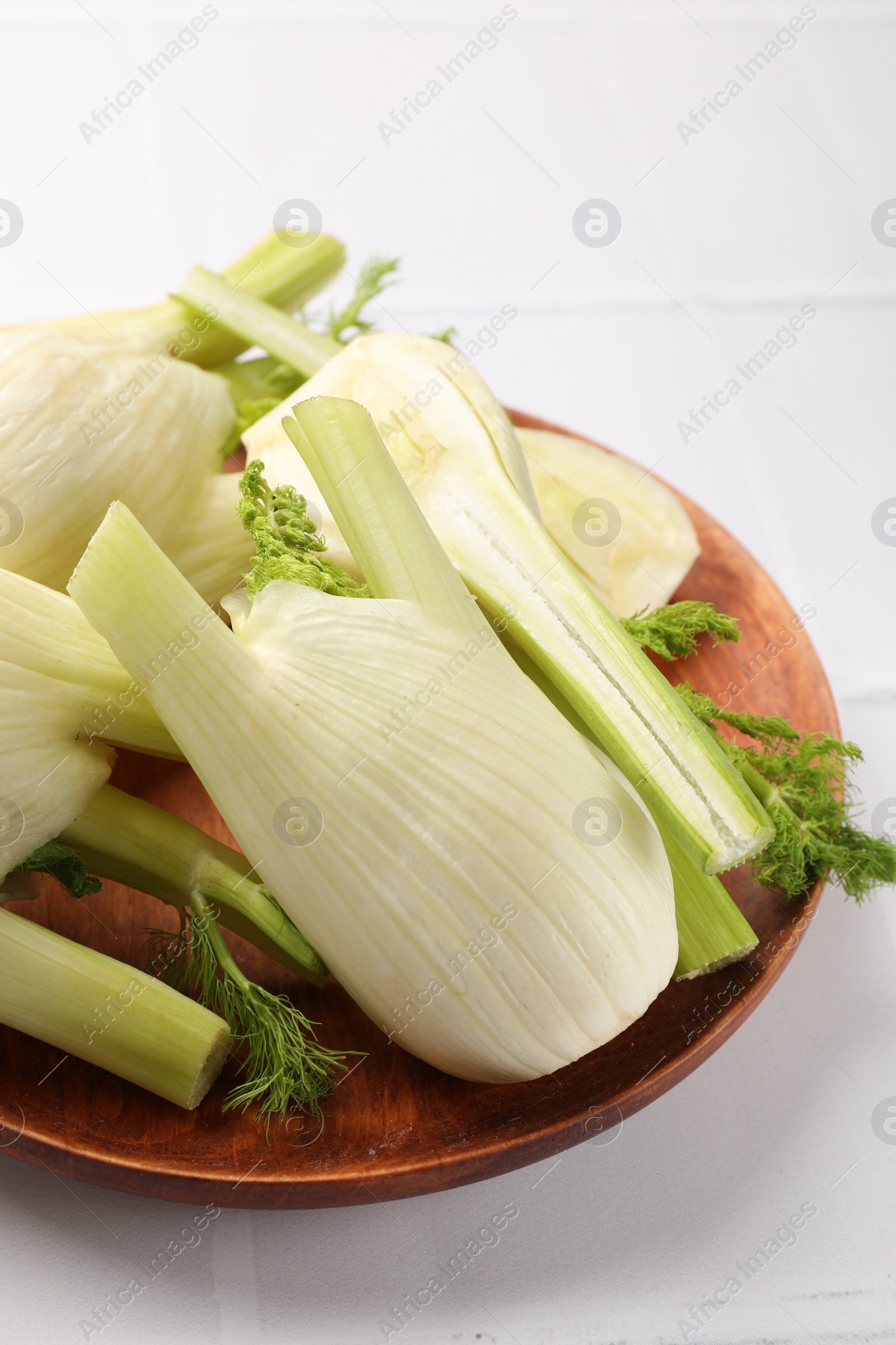 Photo of Fresh raw fennel bulbs on white table, closeup