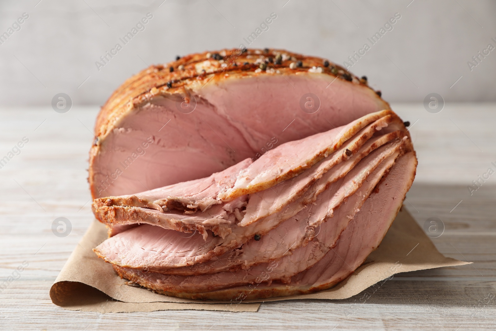 Photo of Delicious sliced baked ham on white wooden table, closeup