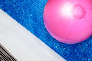 Image of Inflatable beach ball floating in swimming pool, above view 