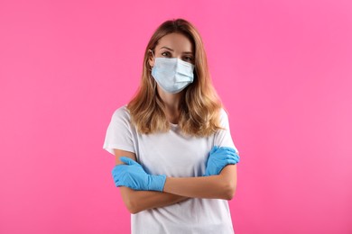 Photo of Young woman in medical gloves and protective mask on pink background