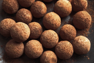 Photo of Tasty chocolate truffles on dark background, closeup