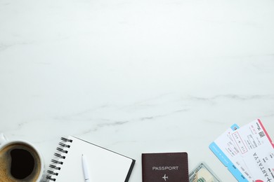 Flat lay composition with passport, notebook and tickets on white marble table, space for text. Business trip