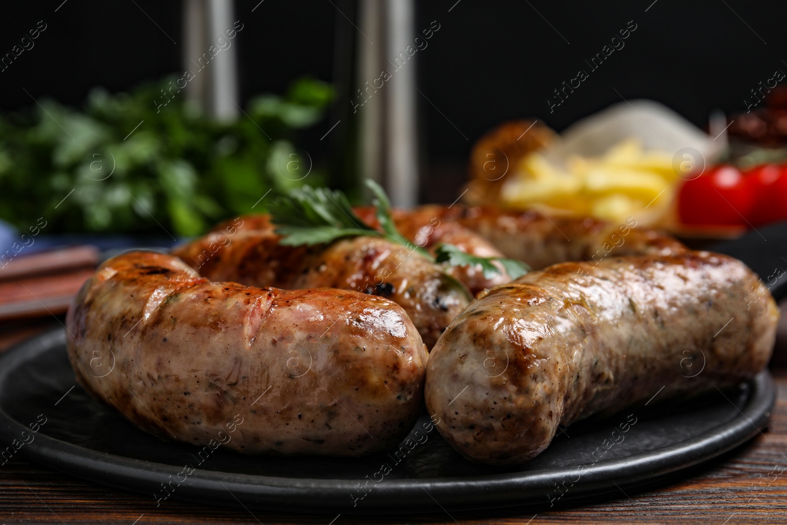 Photo of Delicious grilled sausages on wooden table, closeup