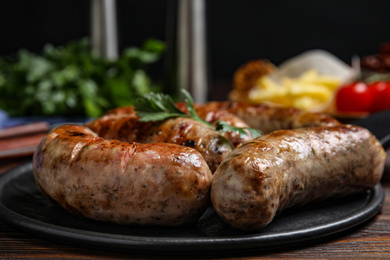 Delicious grilled sausages on wooden table, closeup