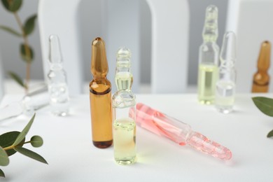 Photo of Stylish presentation of different skincare ampoules on white background, closeup