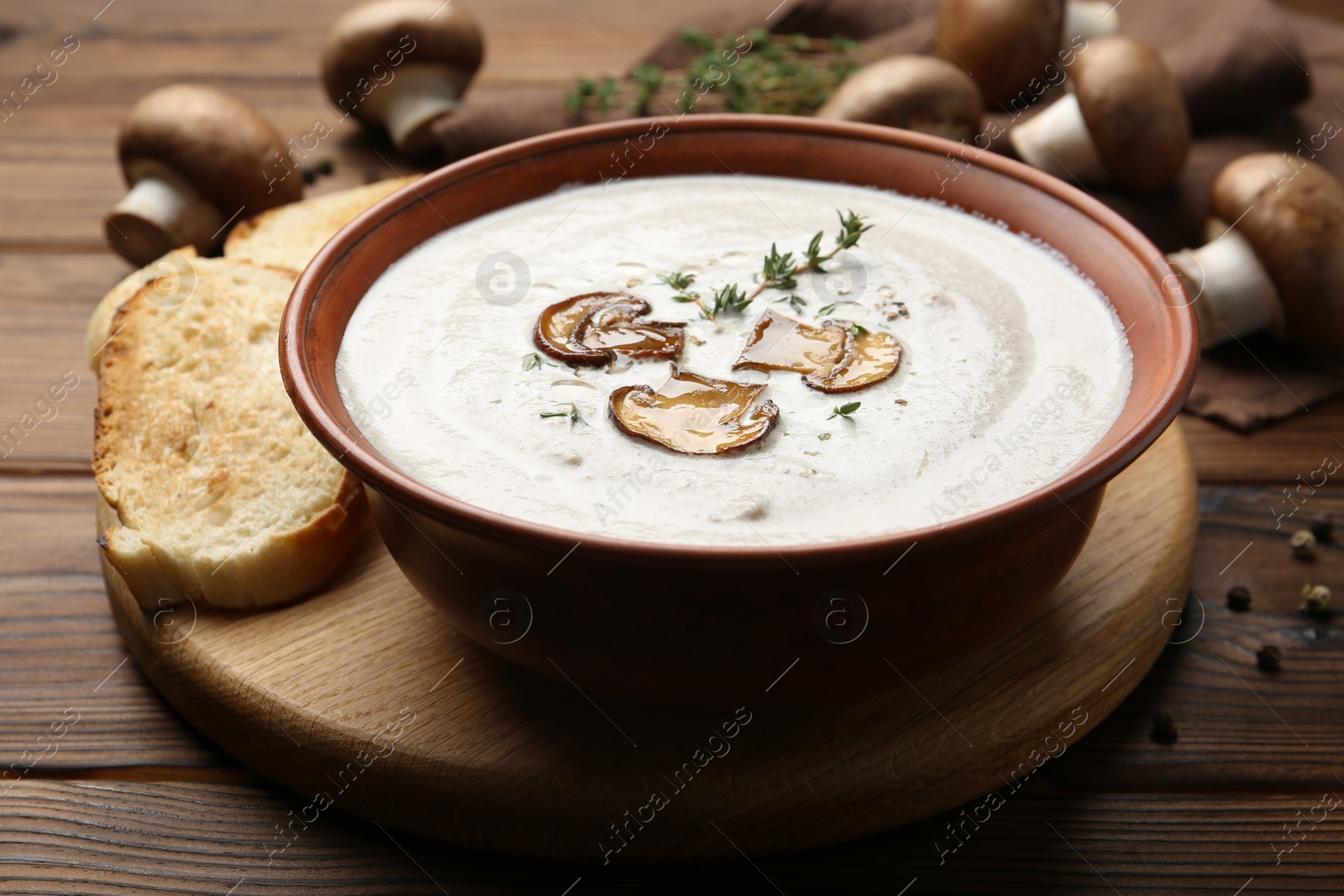 Photo of Fresh homemade mushroom soup in ceramic bowl on wooden table