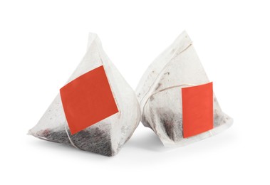 Photo of New pyramid tea bags on white background