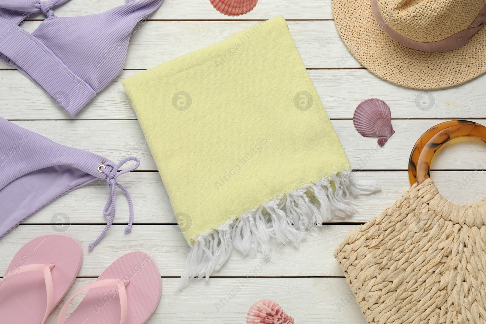 Photo of Towel and different beach items on white wooden background, flat lay