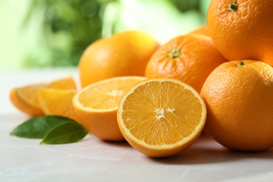 Photo of Ripe oranges on table against blurred background, closeup