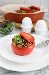 Photo of Delicious stuffed tomato with minced beef, bulgur and mushrooms on white marble table, closeup