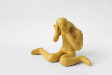 Photo of Plasticine figure of crying human on white background