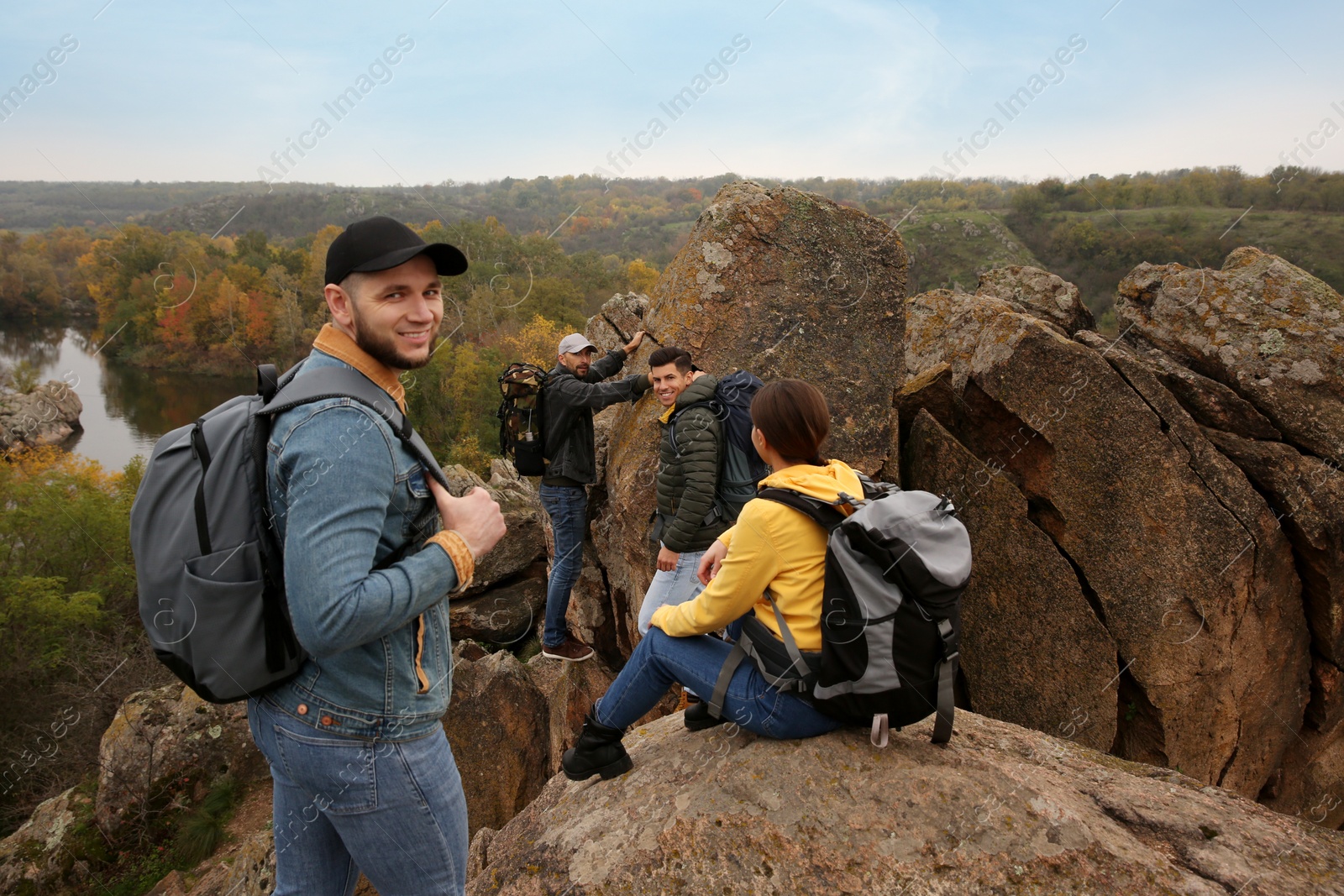 Photo of Group of hikers with backpacks climbing down mountain