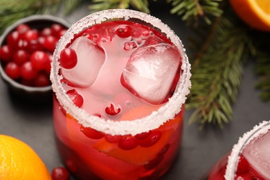 Photo of Tasty cranberry cocktail with ice cubes in glass on table, closeup