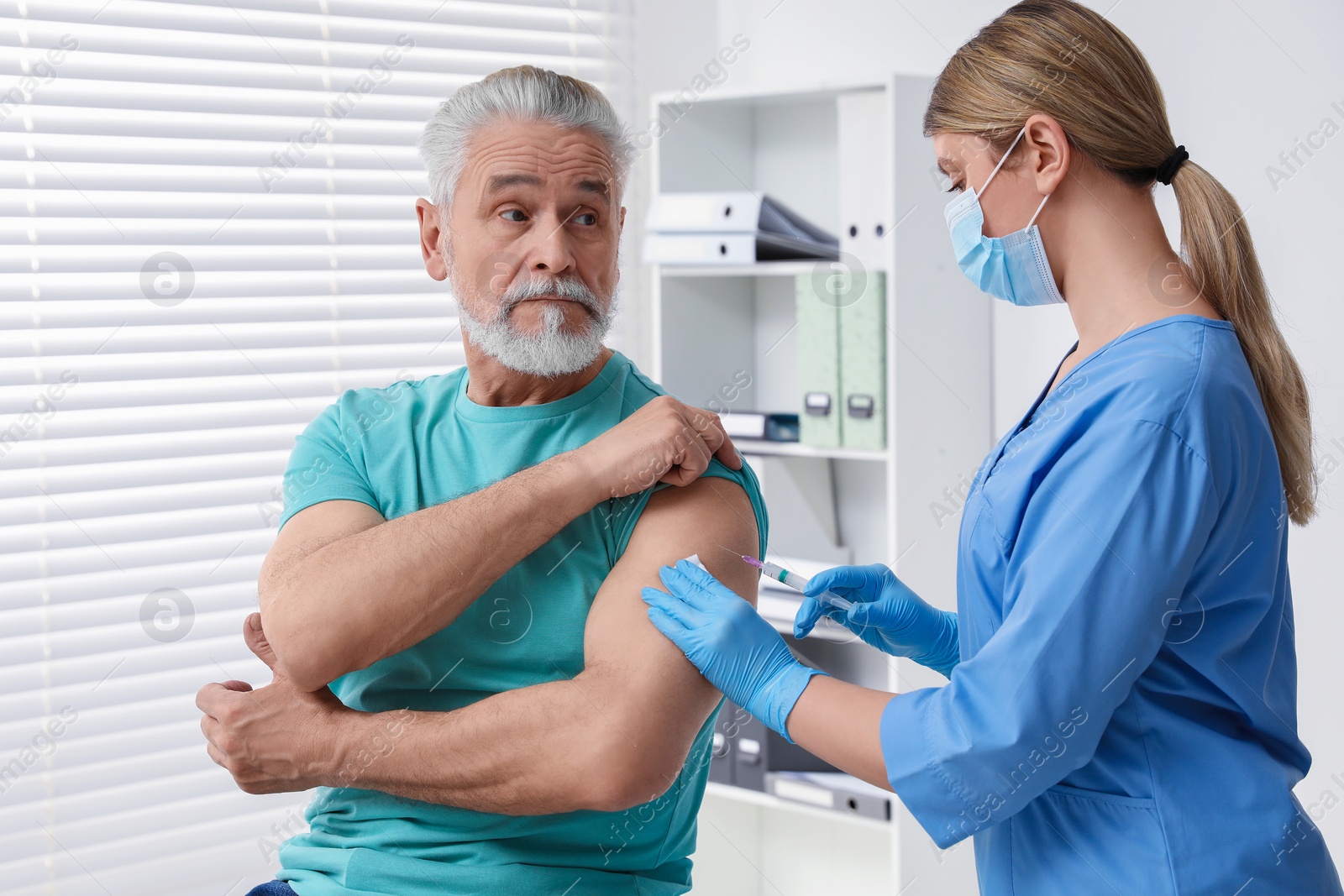 Photo of Doctor giving hepatitis vaccine to patient in clinic