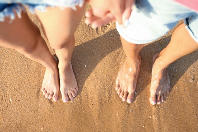 Photo of Young couple resting together at beach, top view.