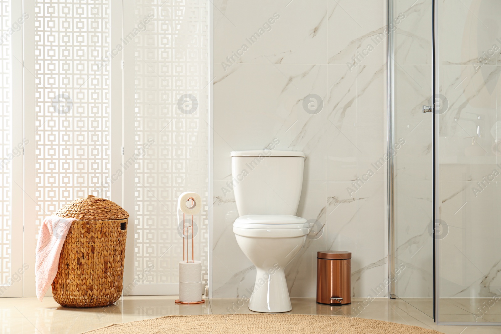 Photo of Toilet bowl near shower stall in modern bathroom interior