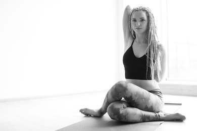 Photo of Young woman practicing yoga indoors
