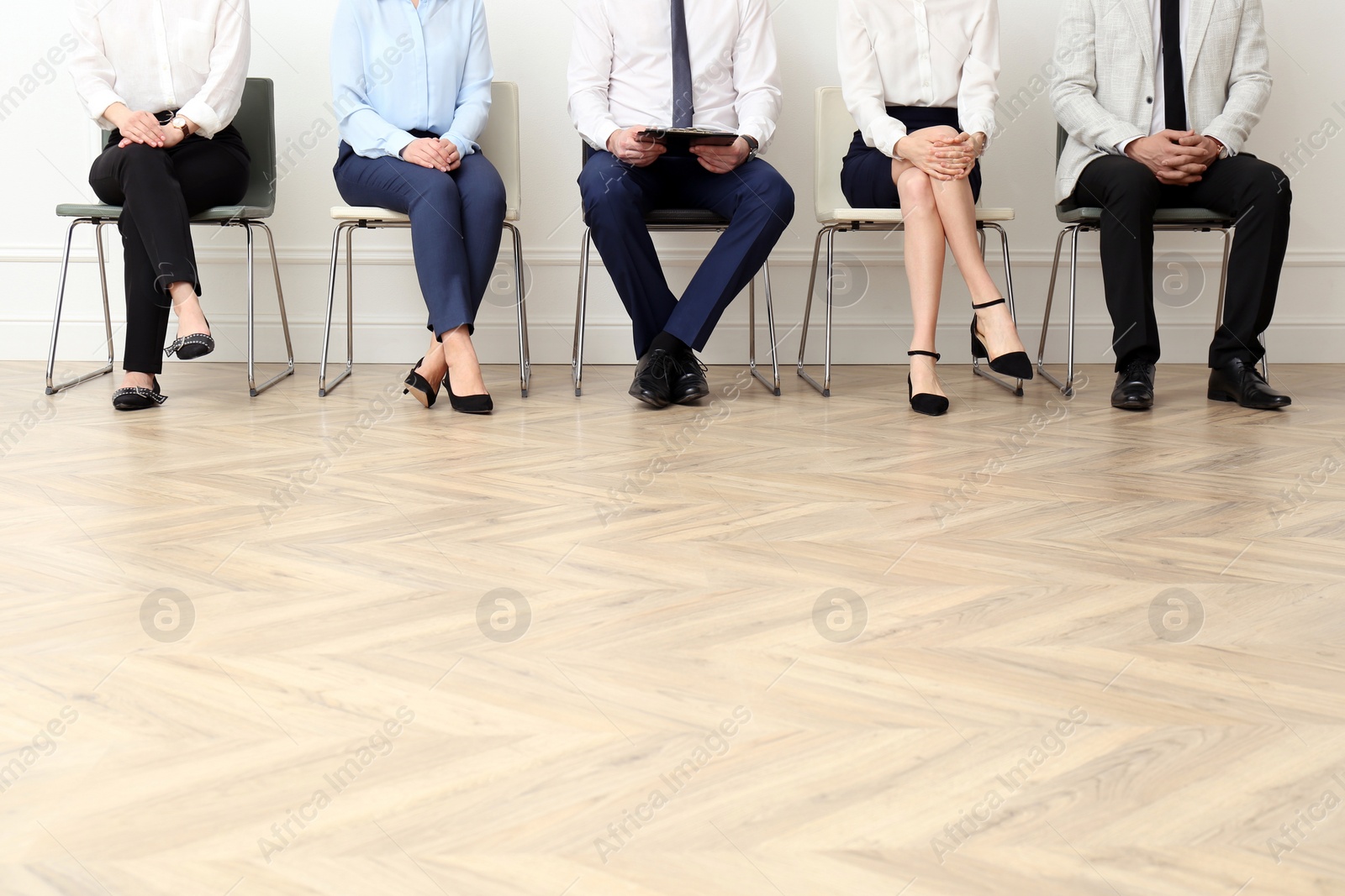 Photo of People waiting for job interview in office hall, closeup