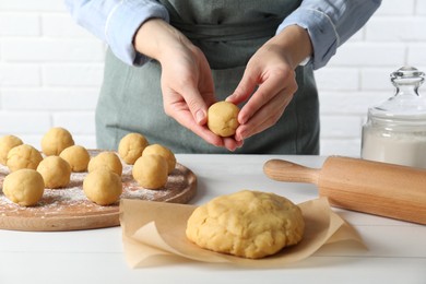 Shortcrust pastry. Woman making dough ball at white wooden table, closeup