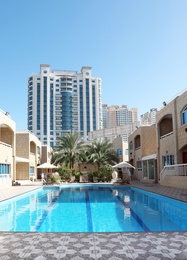 Modern luxury hotel with swimming pool on sunny day