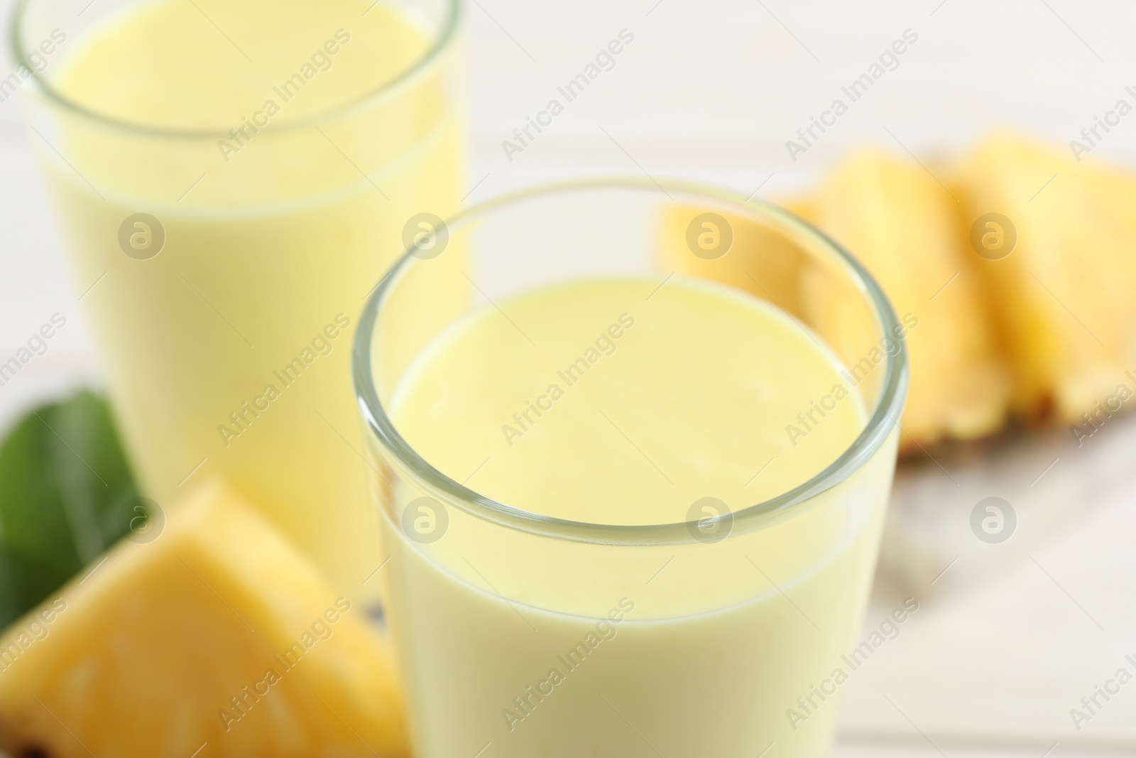 Photo of Tasty fresh pineapple smoothie on table, closeup