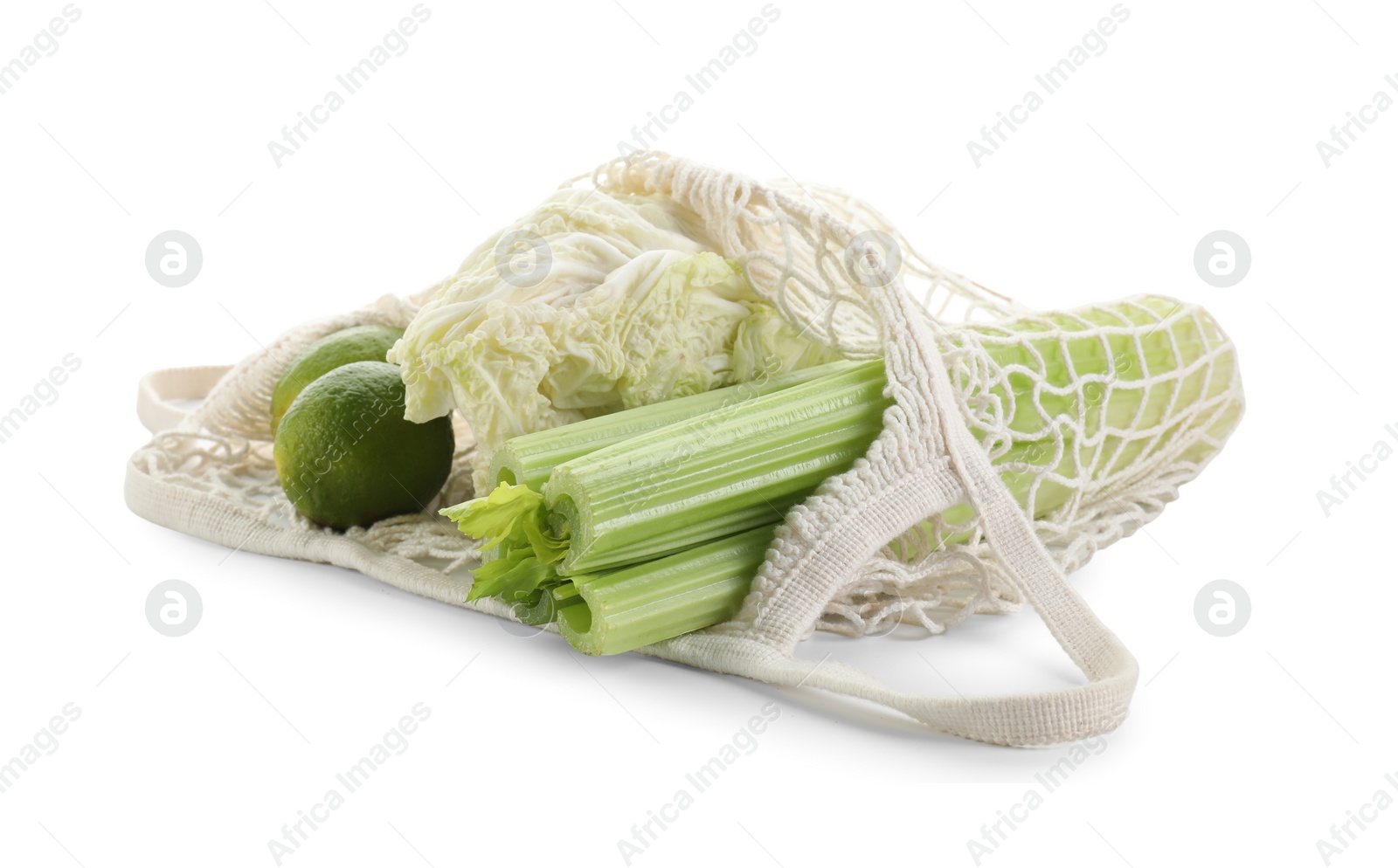 Photo of String bag with different vegetables isolated on white