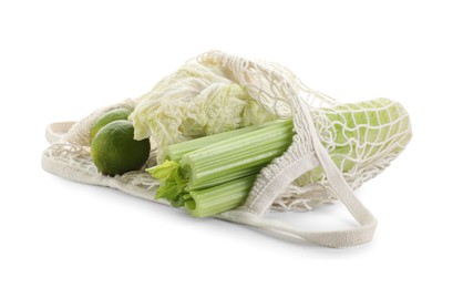 Photo of String bag with different vegetables isolated on white