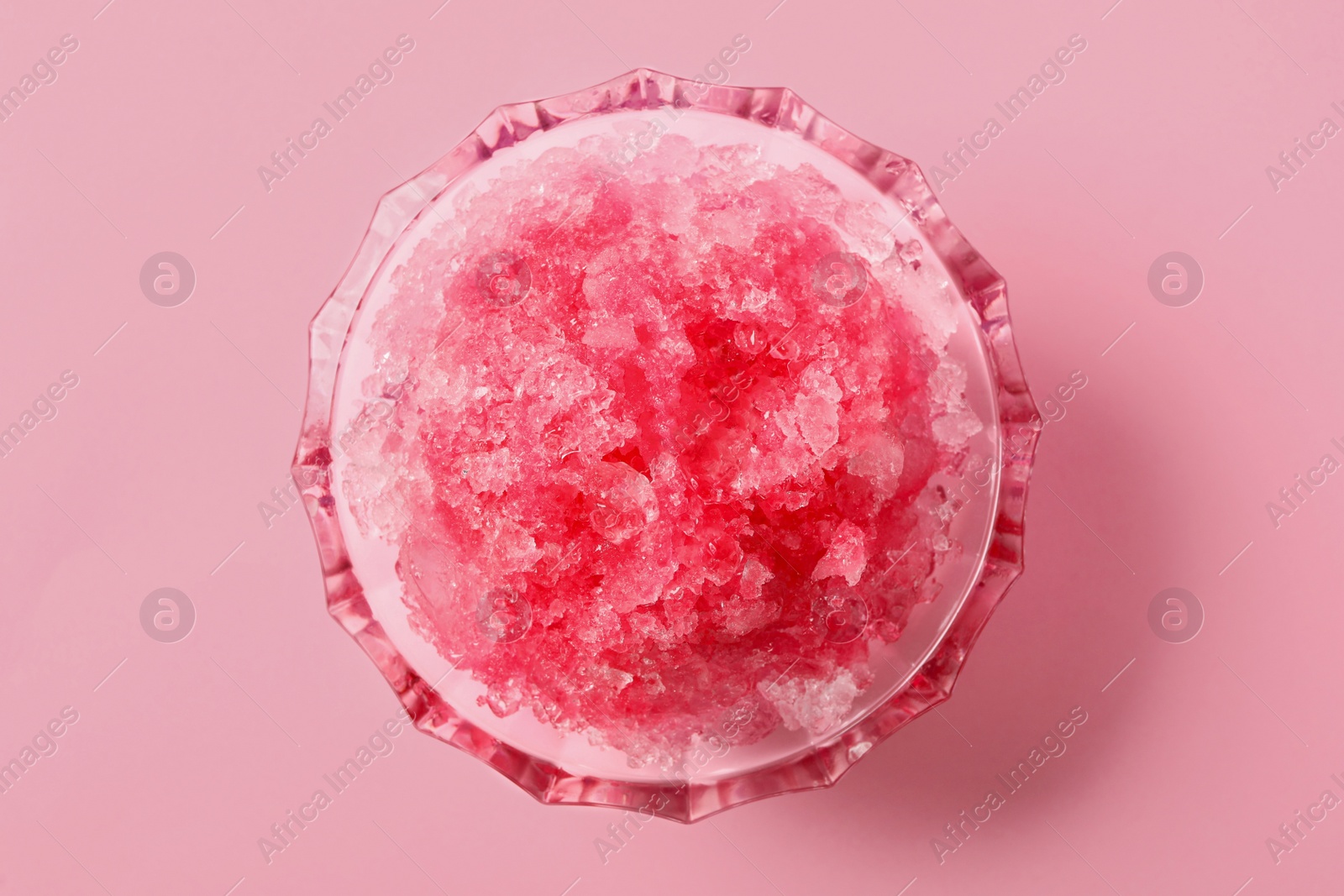 Photo of Shaving ice in glass dessert bowl on pink background, top view