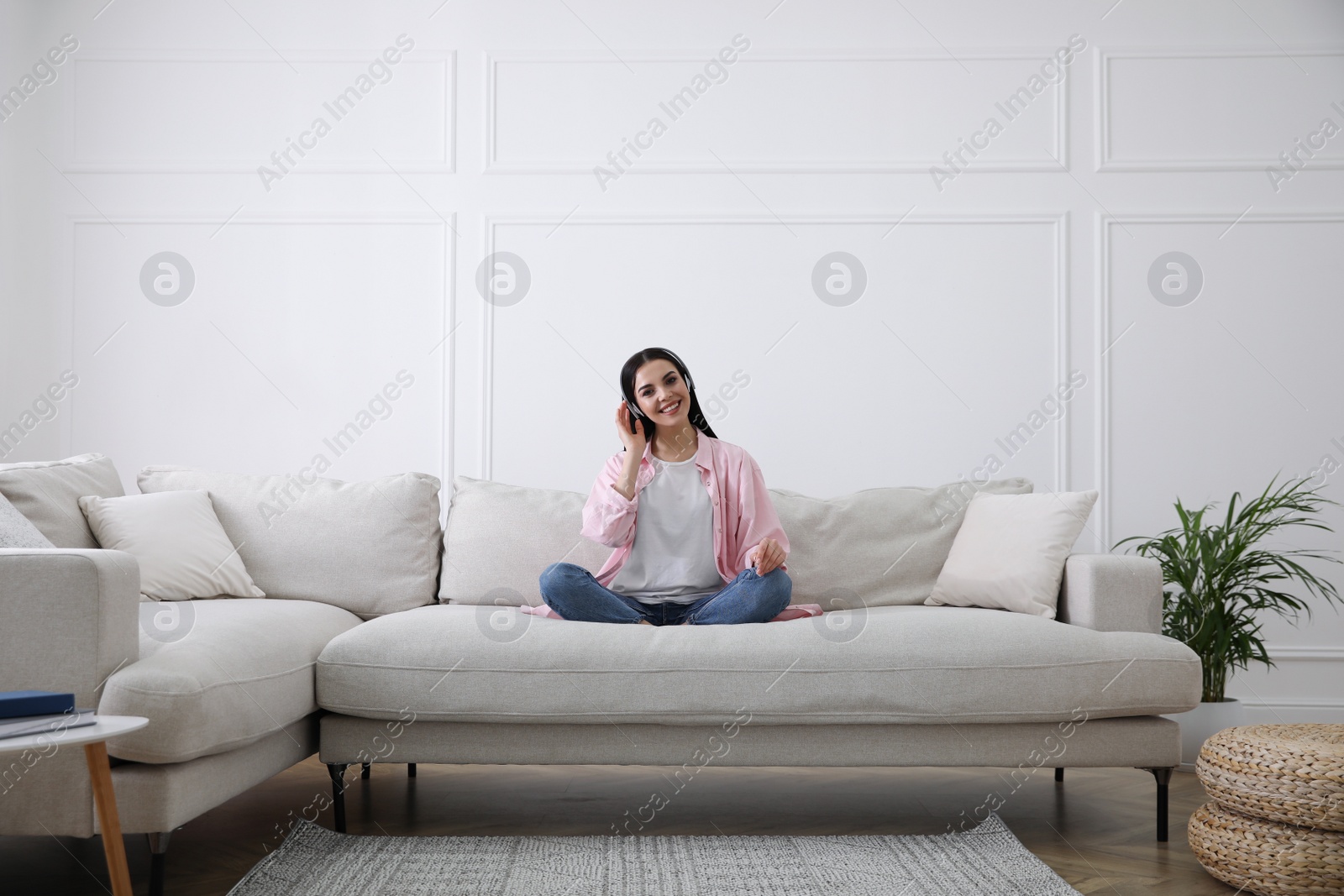 Photo of Woman with headphones on sofa in living room