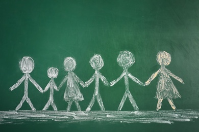 Drawing of people holding hands together on chalkboard. Unity concept