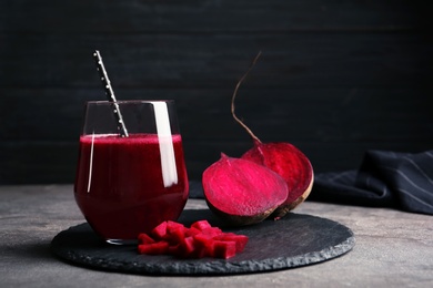 Slate plate with glass of beet smoothie on table