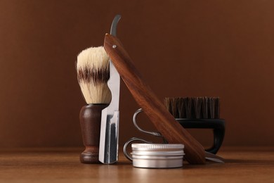 Photo of Moustache and beard styling tools on wooden table