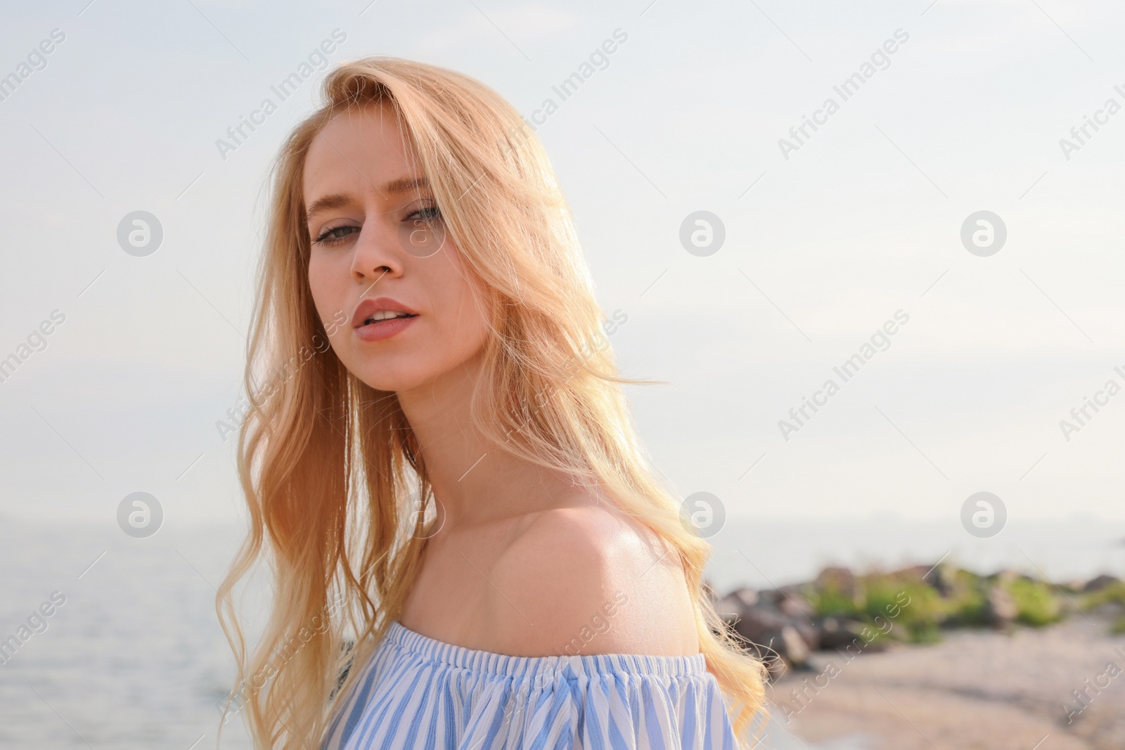 Photo of Beautiful young woman near sea on sunny day