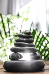 Photo of Table with stack of stones and blurred green leaves on background. Zen concept